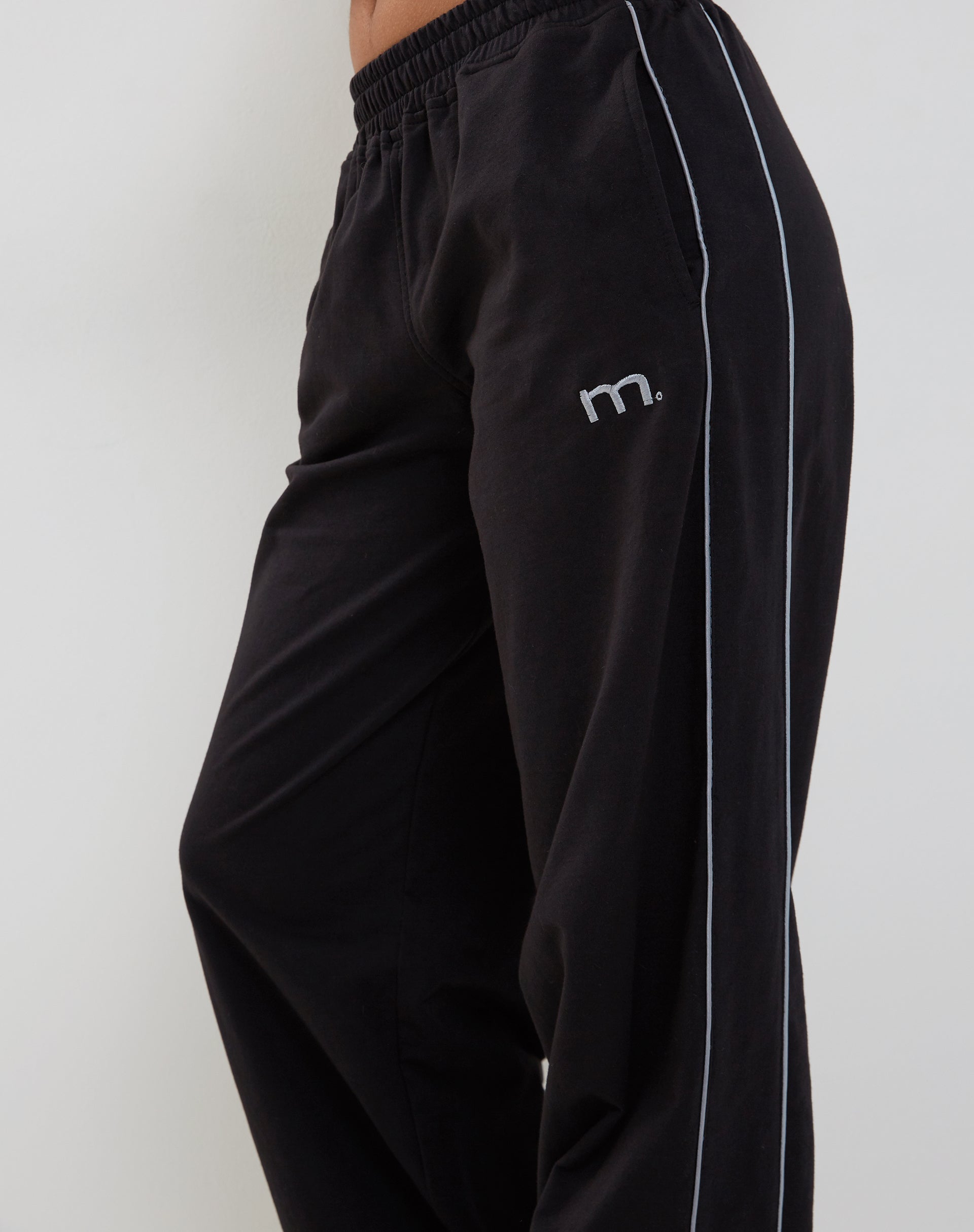 Benton Wide Leg Jogger in Schwarz mit dunkelgrauen Paspeln und 'M'-Stickerei