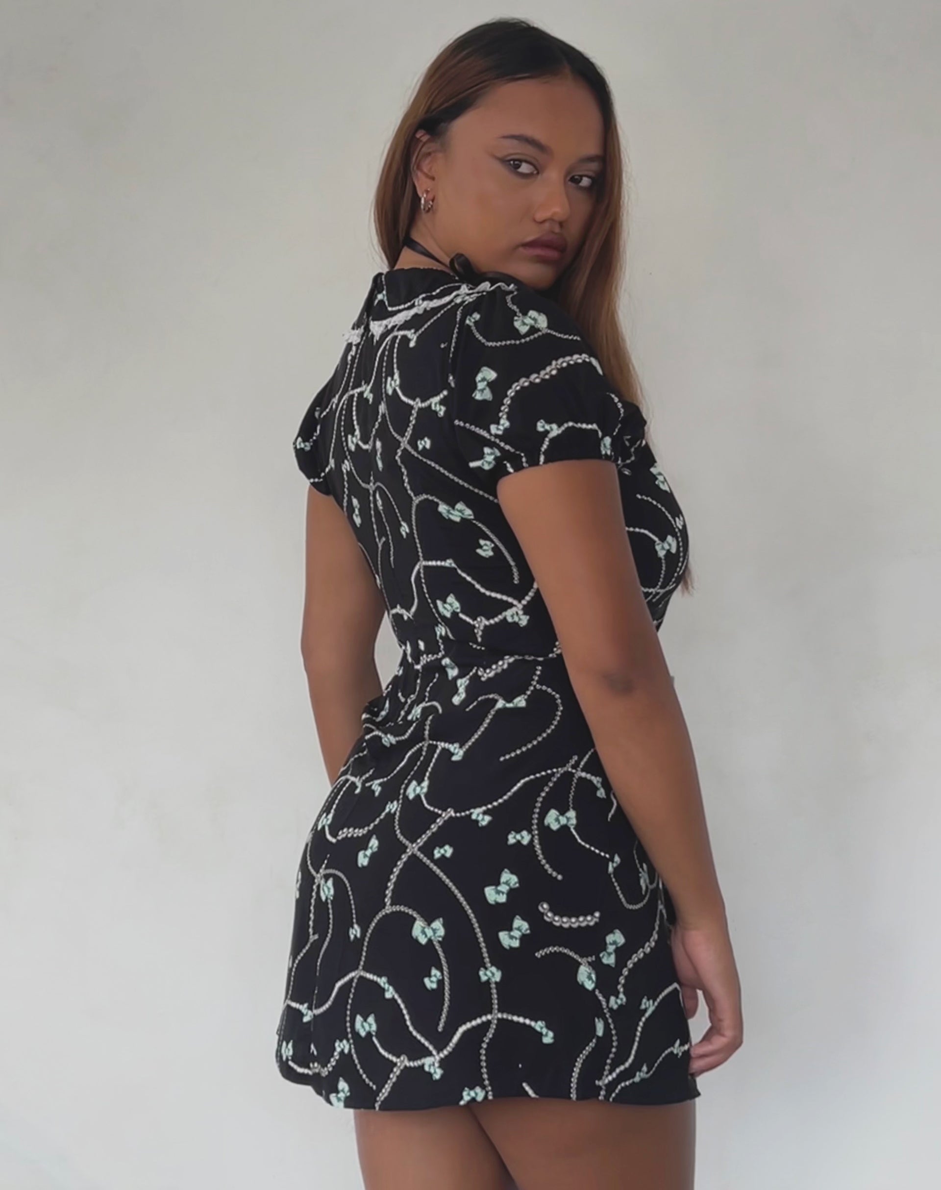 Bild von Sulani Minikleid in Schwarz mit Perlen- und Schleifenprint